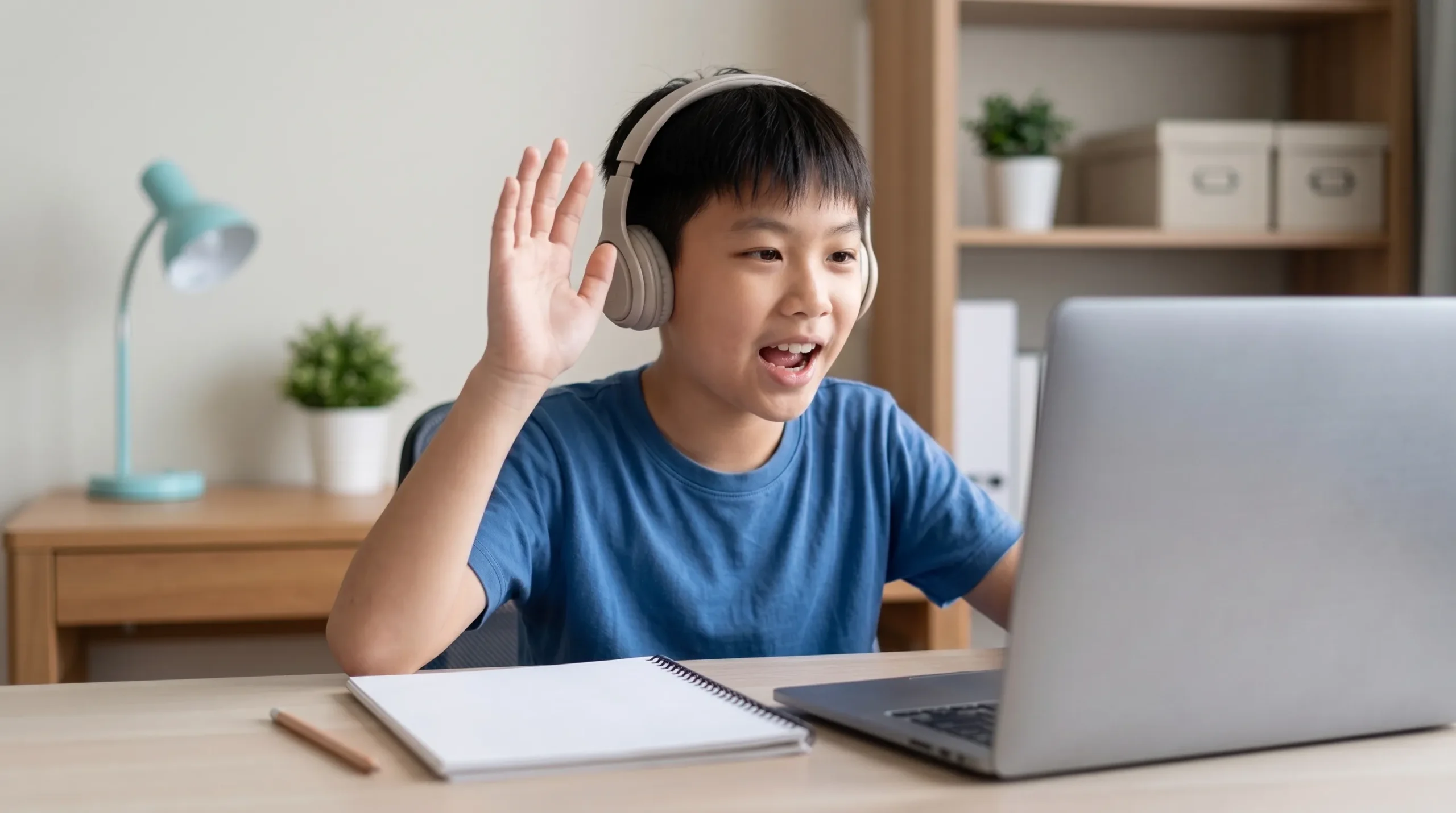 A student raising his hand to answer during a live online lesson